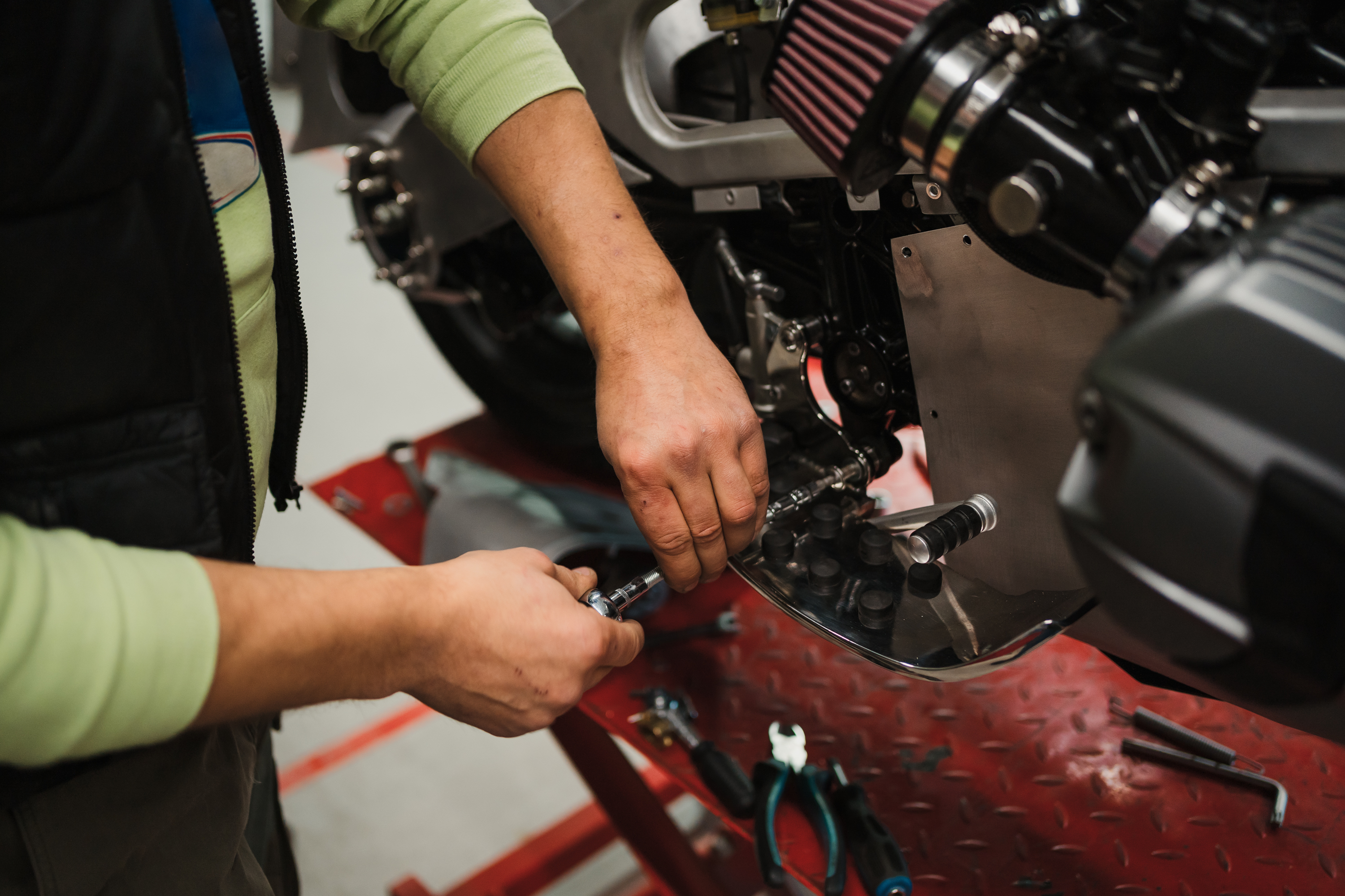 man-fixing-motorcycle-modern-workshop